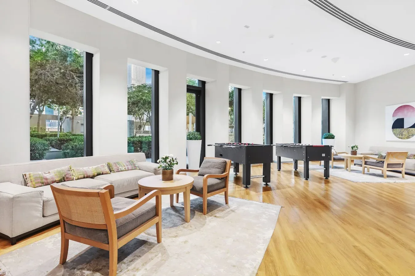 A bright lounge with seating, tables, and several game tables.