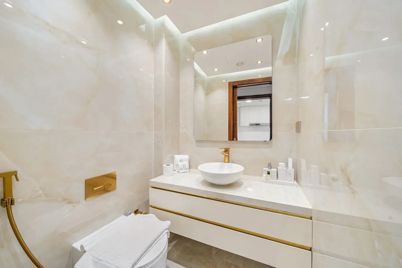 A bright bathroom with a vanity, mirror, and toilet.