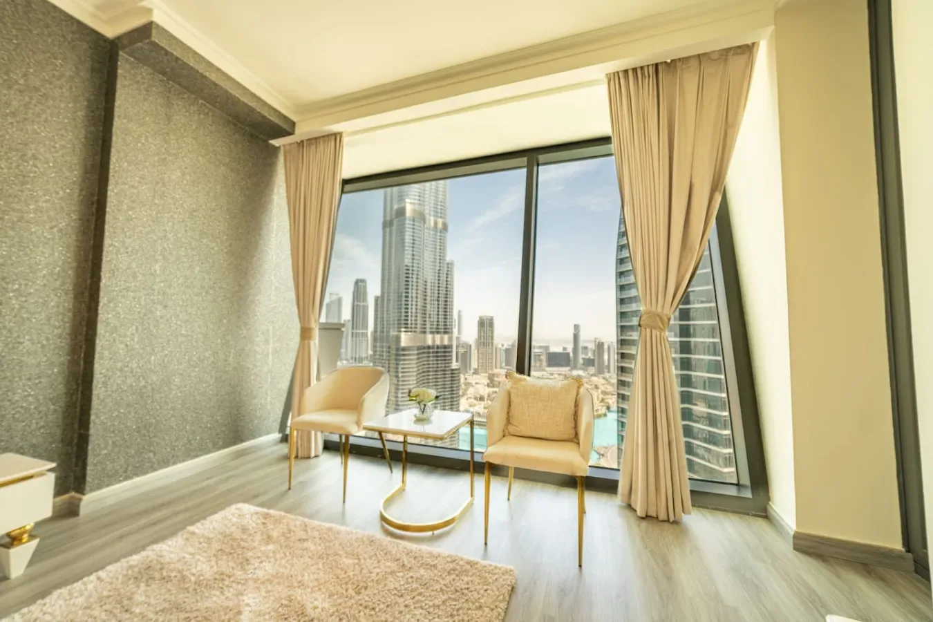 A sitting area by floor-to-ceiling windows overlooks the city skyline.