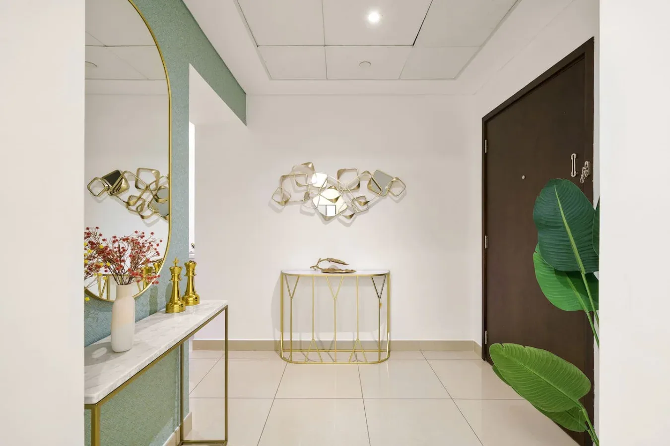 A bright entryway features a narrow console table and abstract wall decor.