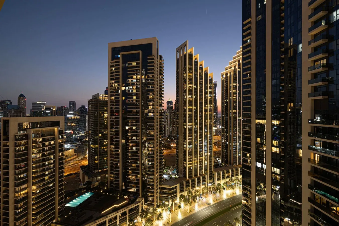 A nighttime cityscape shows illuminated high-rise buildings and streets.