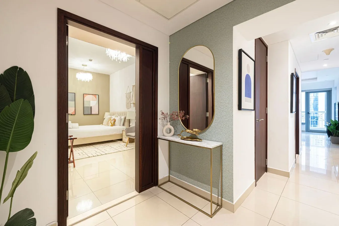 A bright hallway with a console table and an open doorway to a bedroom.