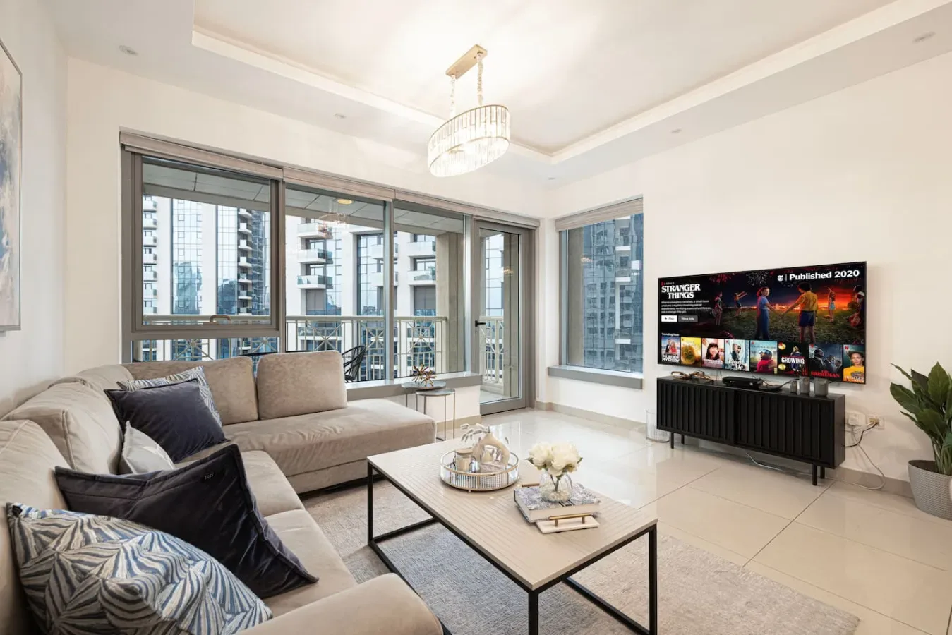 A bright living room with a sectional seating area and large windows.