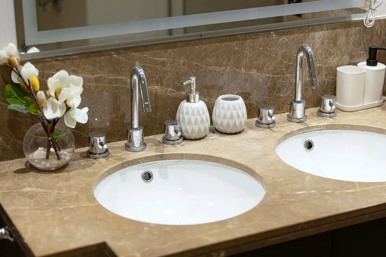 A bathroom vanity with two sinks and a small flower arrangement.