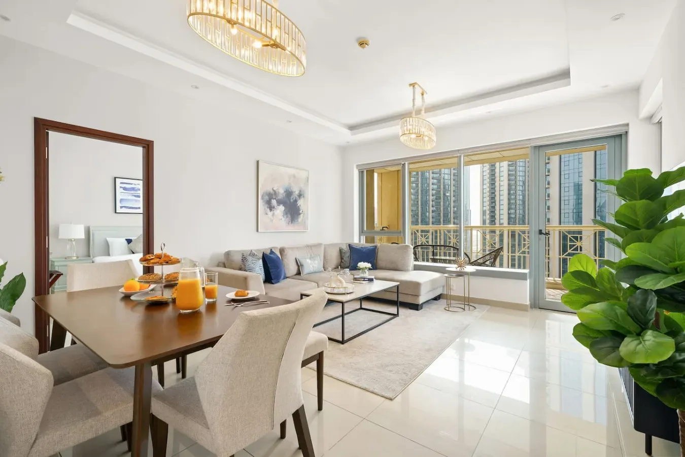A bright living and dining area with seating, a table, and large windows.