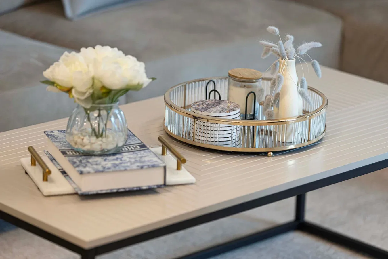 A living room coffee table displays flowers and a decorative tray.