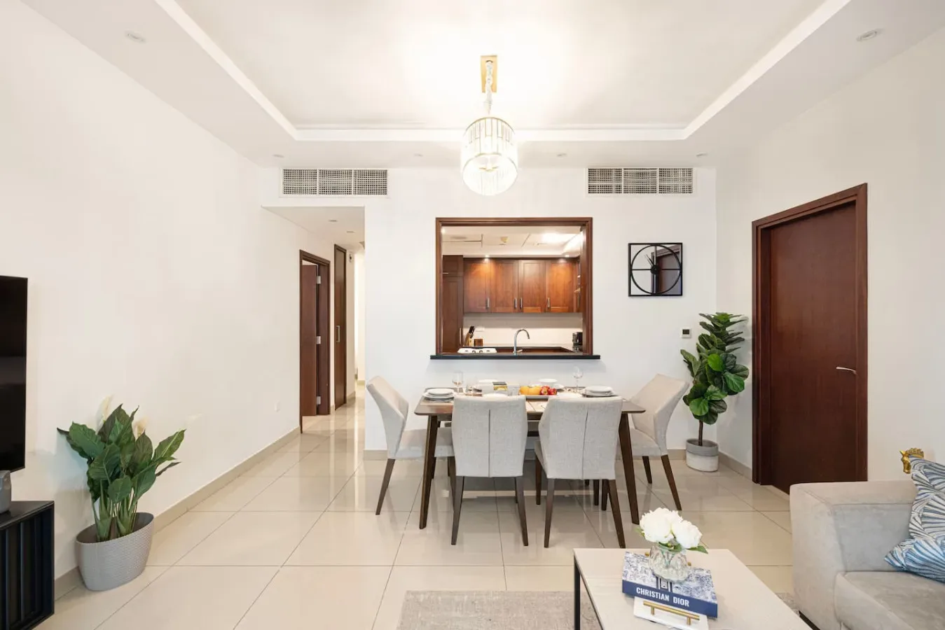 A bright dining area with a table and seating beside an open kitchen.