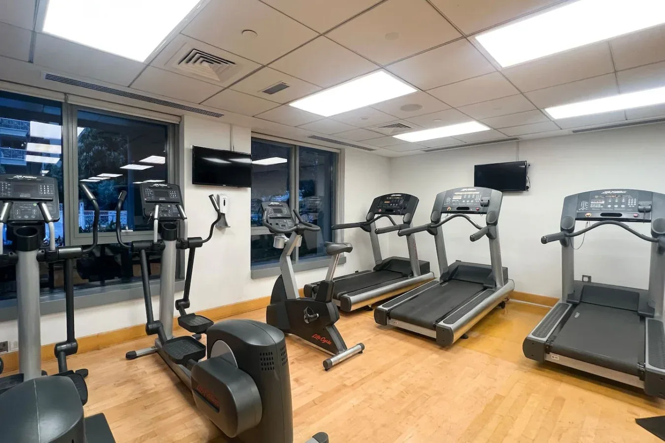 A fitness room with several treadmills and other exercise equipment.