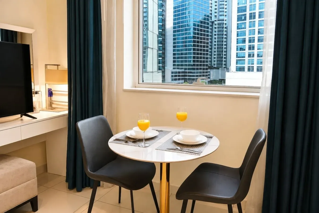 A small dining area with a round table and seating beside a large window.