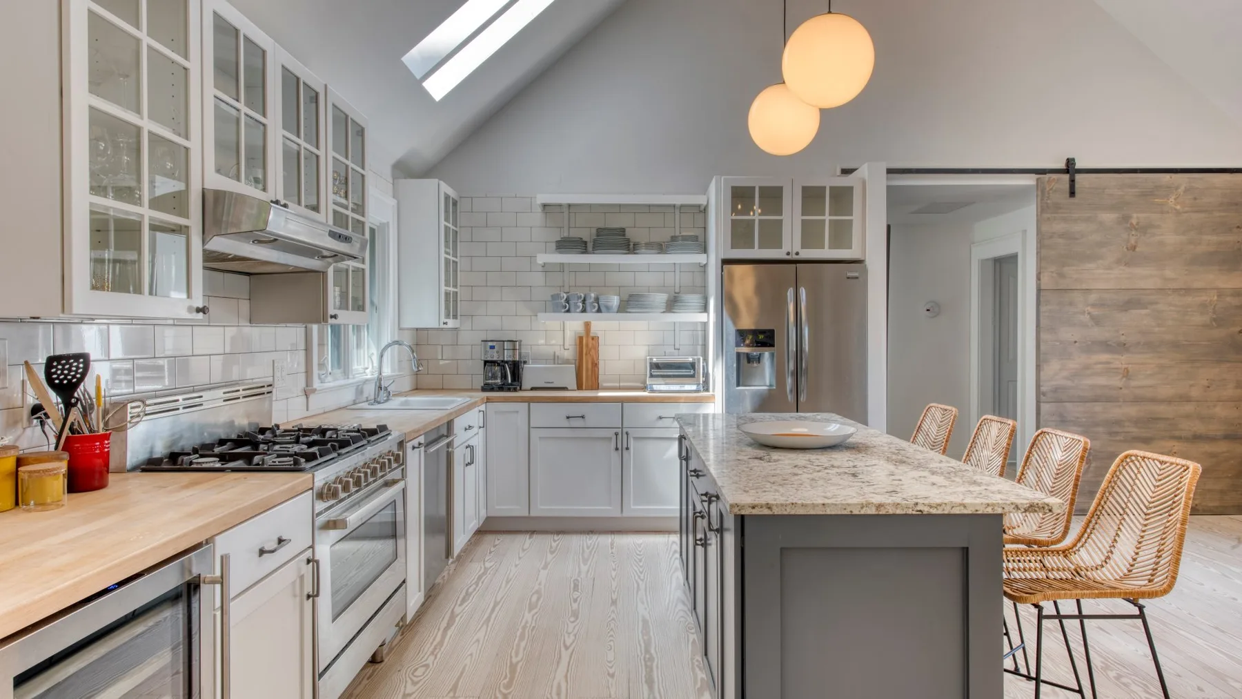 Una cocina luminosa con una isla central y gabinetes de tonos claros.