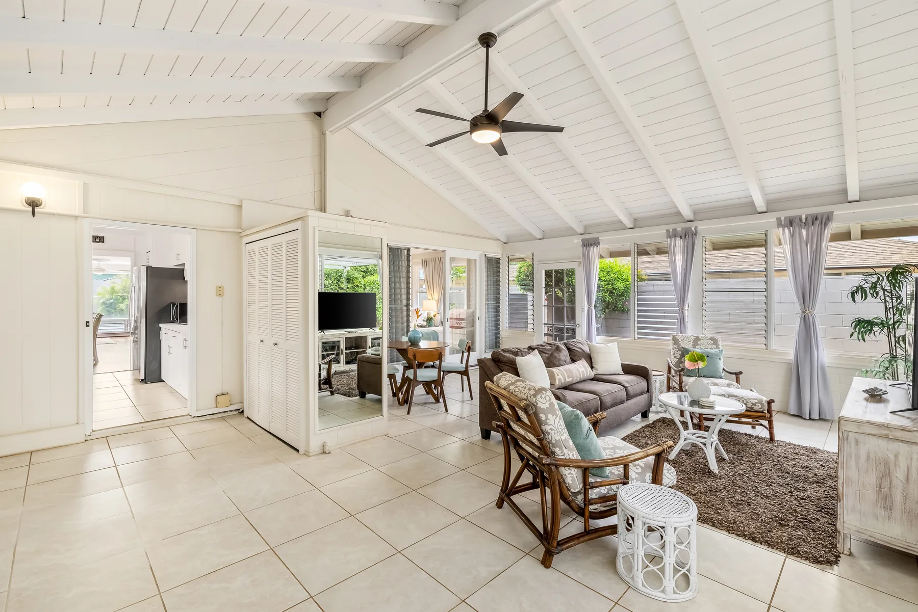 A bright living room with seating, a coffee table, and large windows.