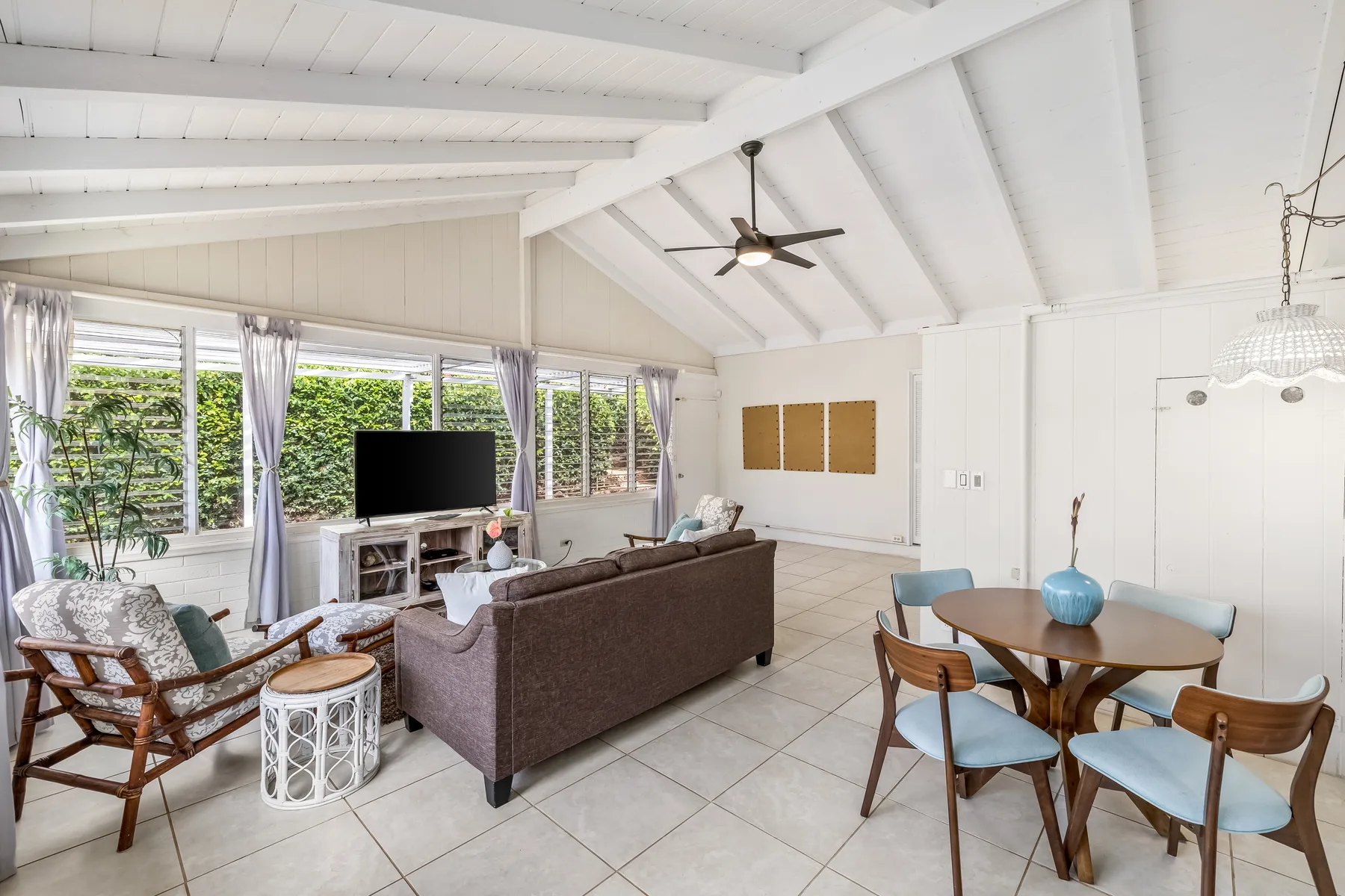 A bright open-plan living and dining room with seating and a dining table.