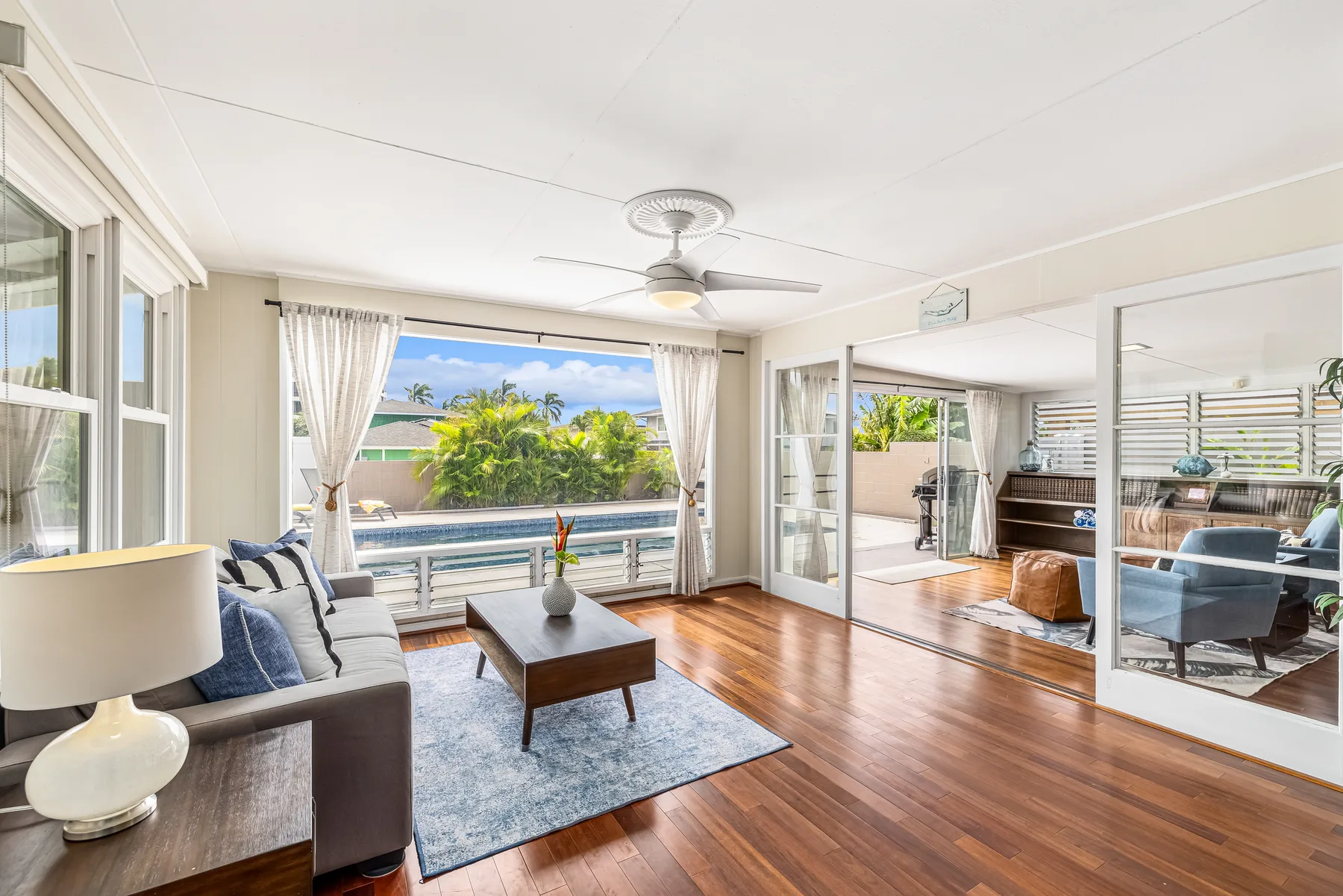 A bright living room opens onto a balcony through wide sliding glass doors.
