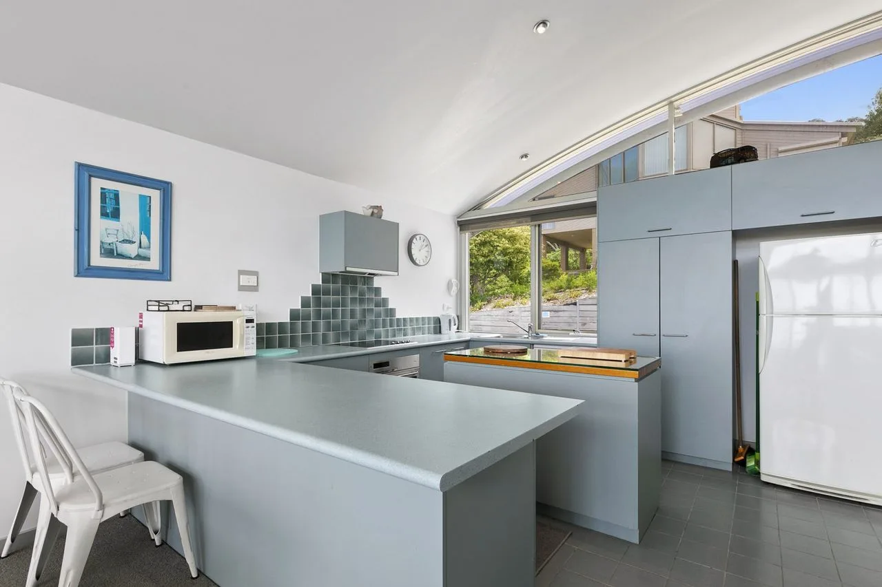 Una cocina moderna con una isla grande y ventanas amplias.