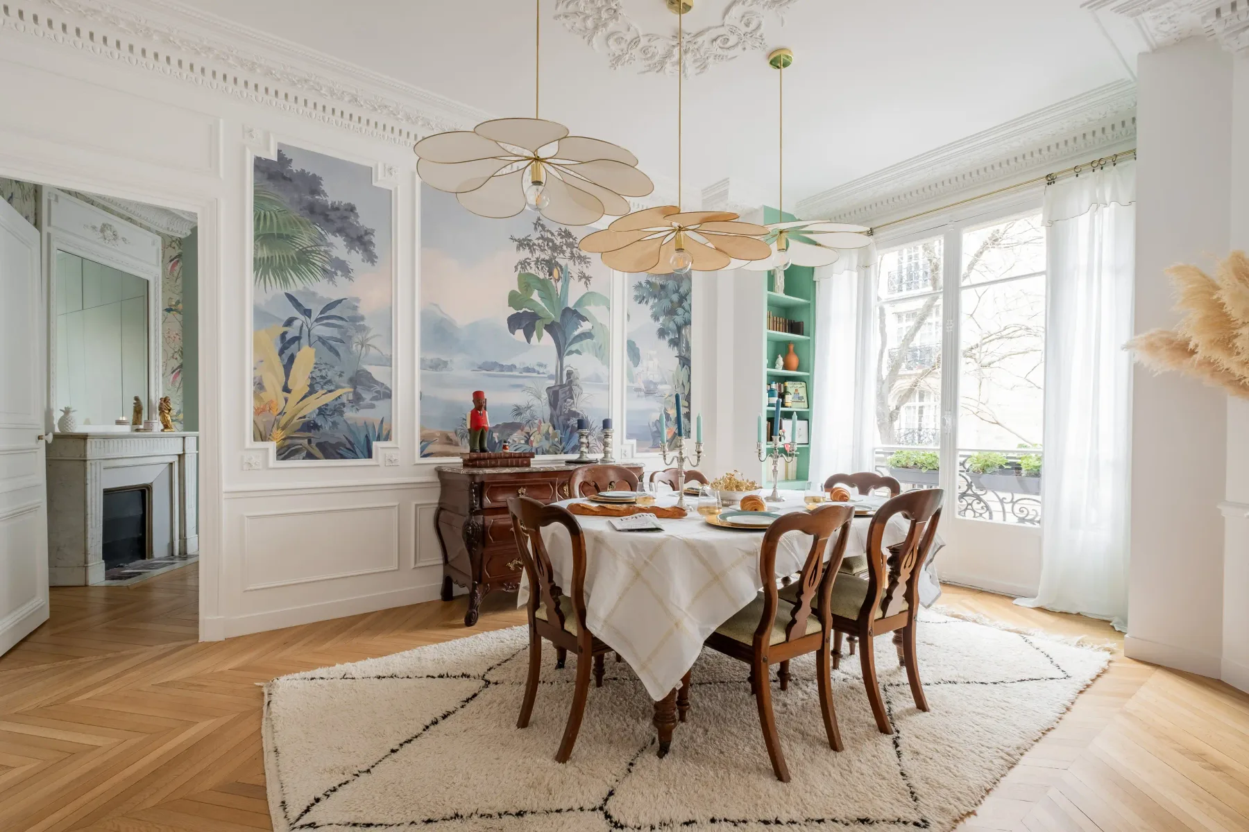 A bright dining room with a table set beneath decorative pendant lights.
