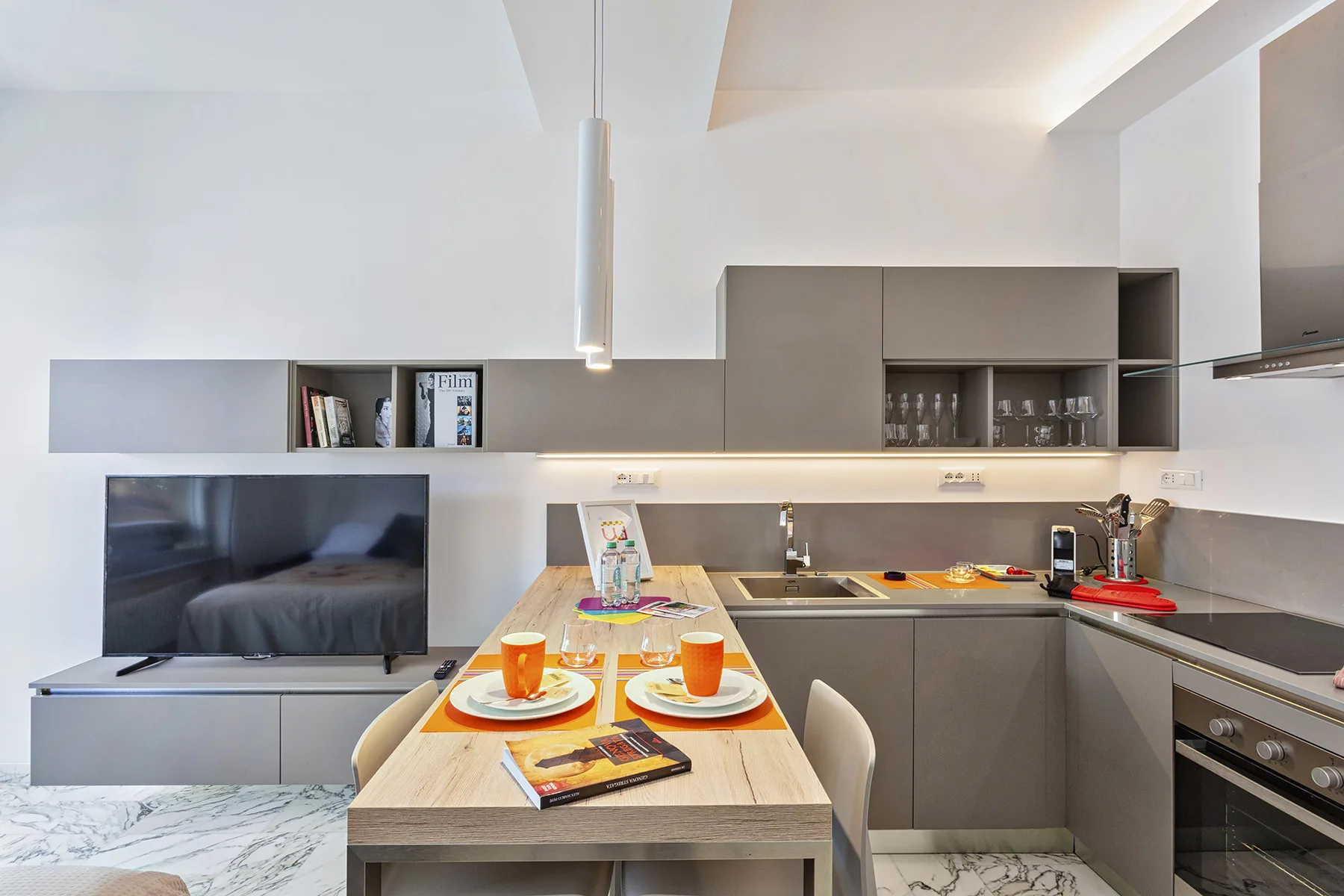 Una cocina moderna con una mesa de comedor y un televisor.