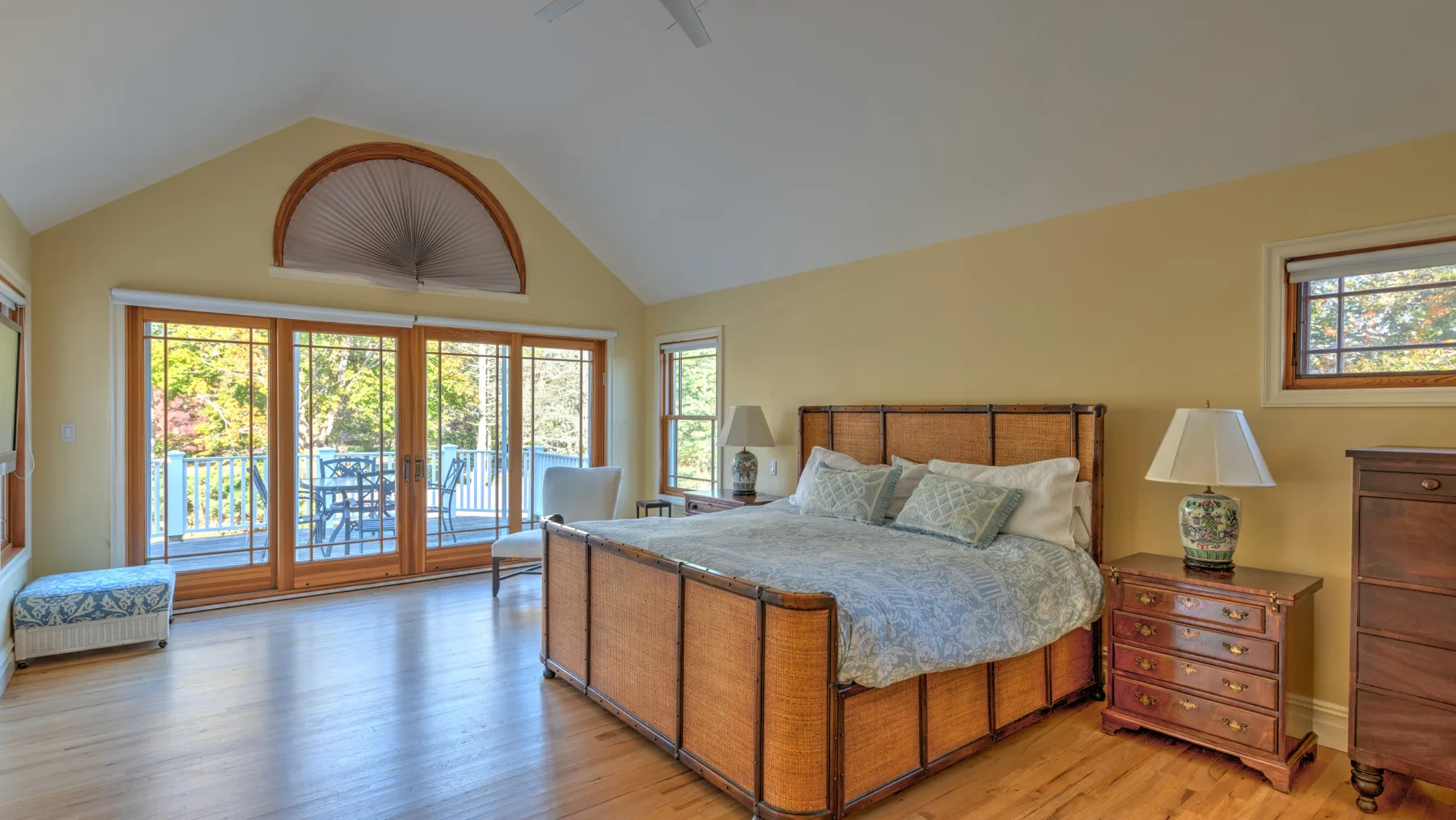 A bedroom with a large bed and glass doors opening onto a balcony.