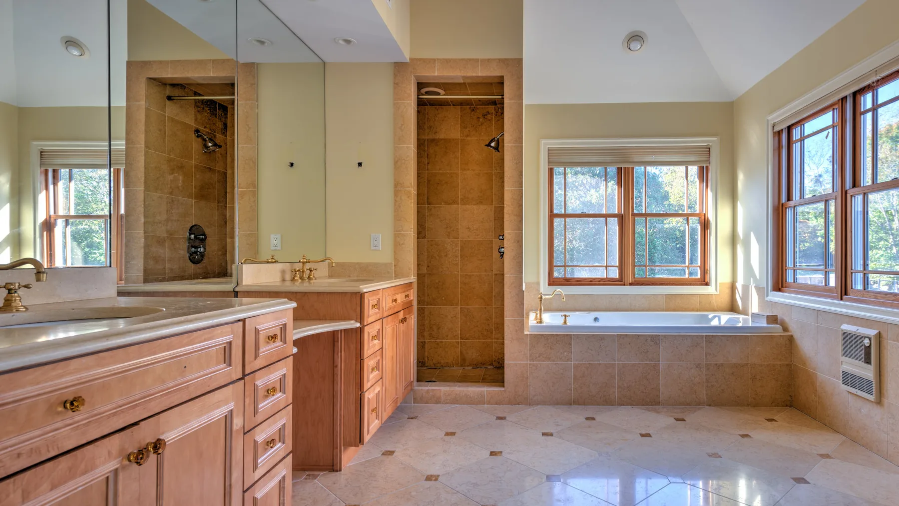 A bright bathroom features a large bathtub beneath a window.