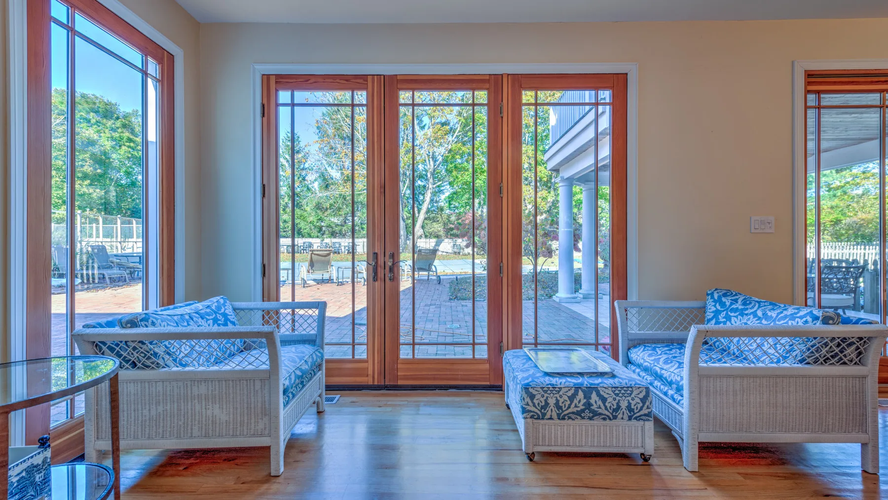 A bright living room with seating beside large glass doors and windows.