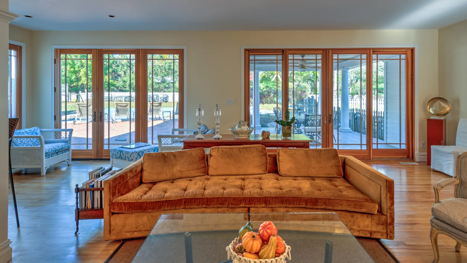 A bright living room with a large sofa and glass doors opening onto a patio.