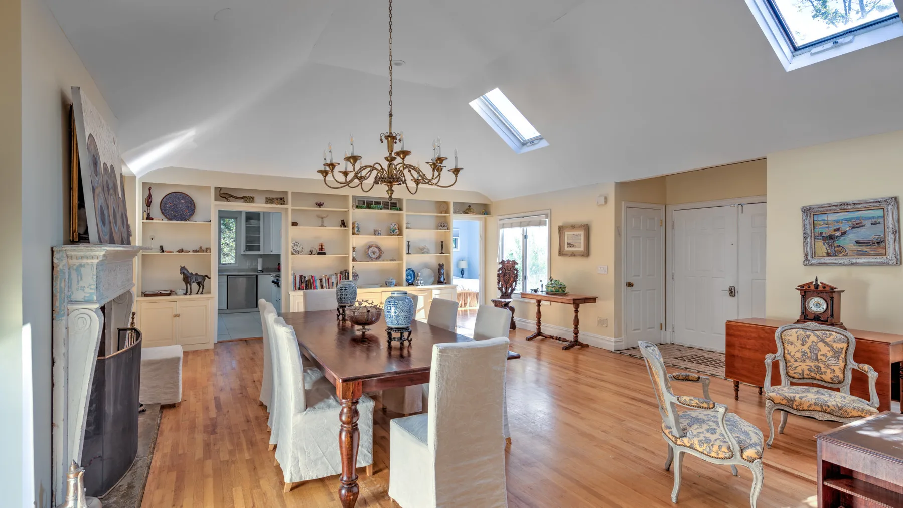 A bright living room with a dining table, seating, and built-in shelves.