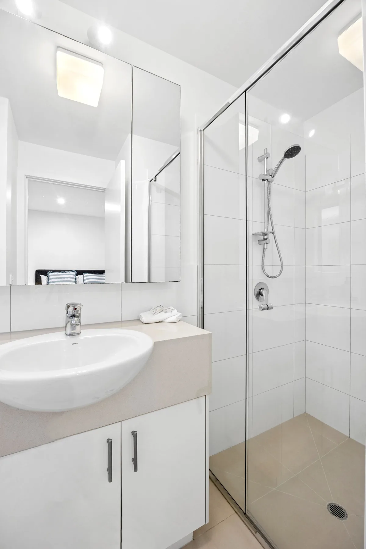 Un baño luminoso con lavabo y ducha de vidrio.