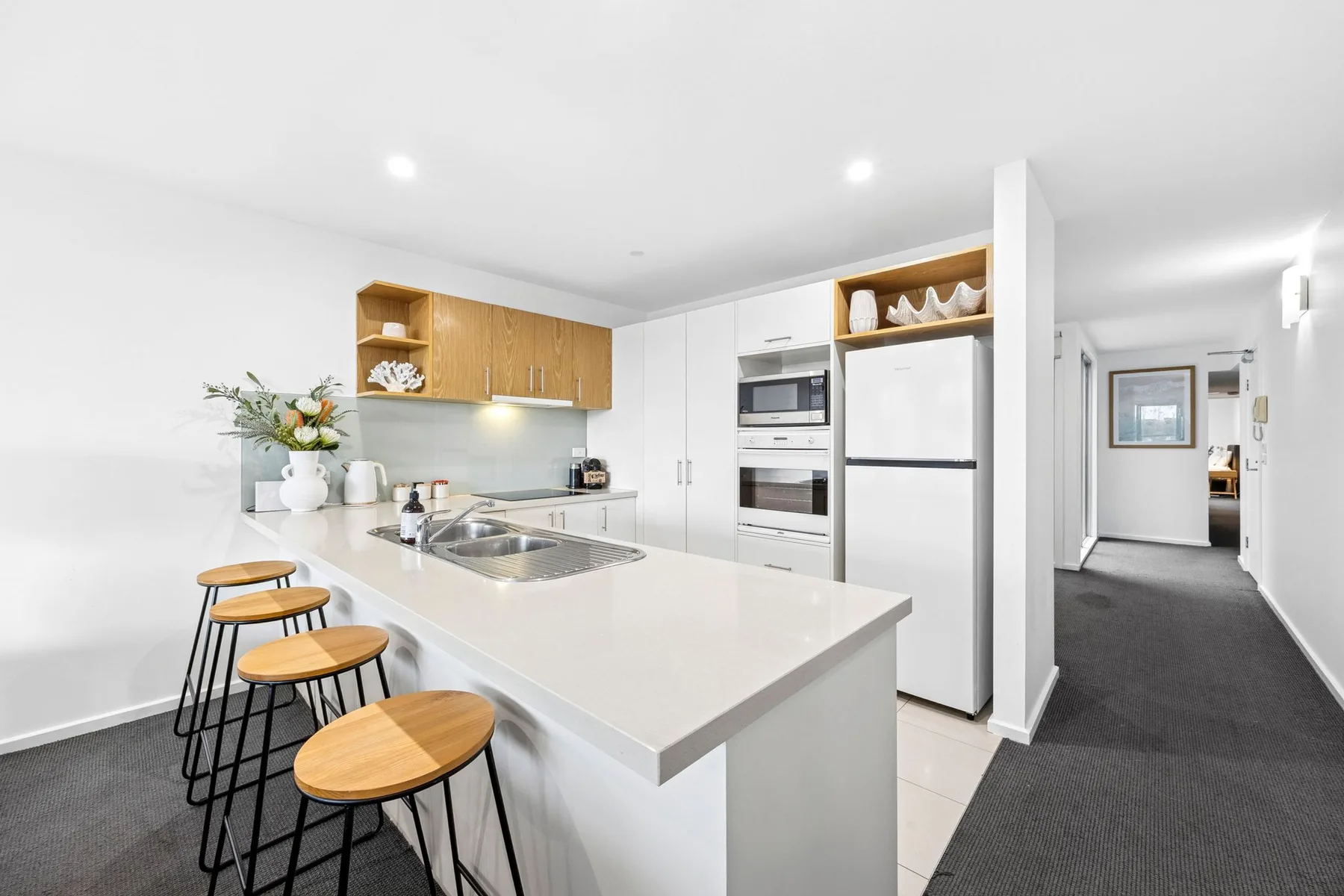 Una cocina moderna y luminosa con una isla grande y taburetes de madera.