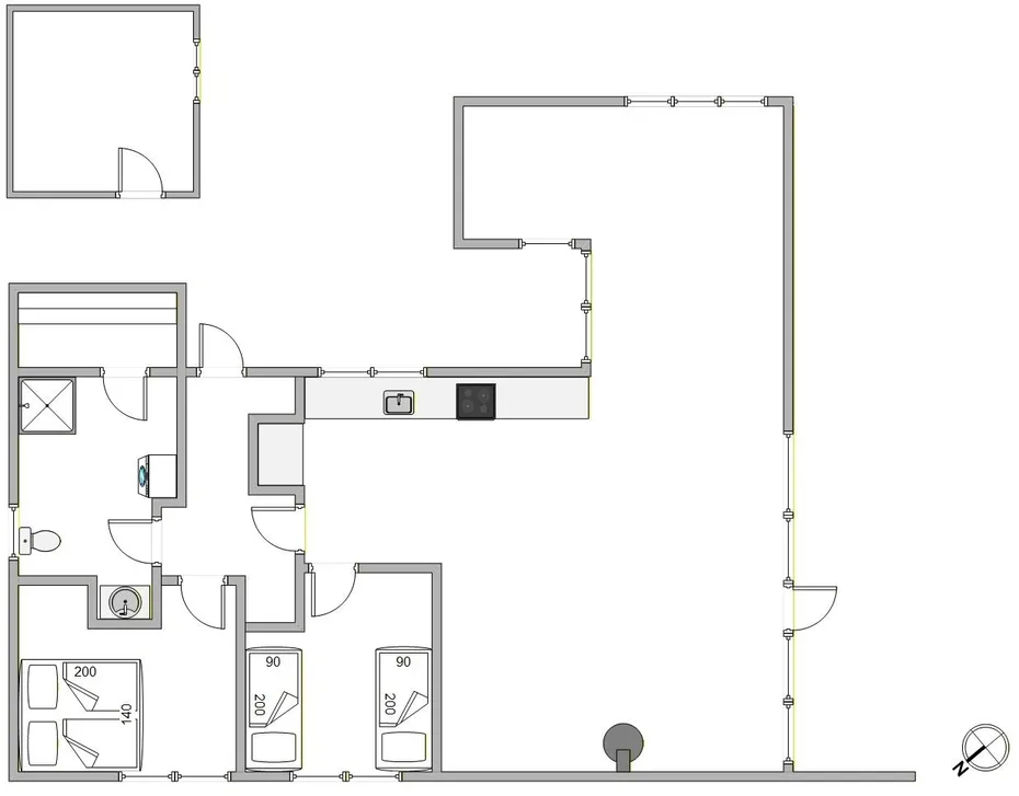 Un plano muestra una sala amplia, una zona de cocina y varias habitaciones pequeñas.