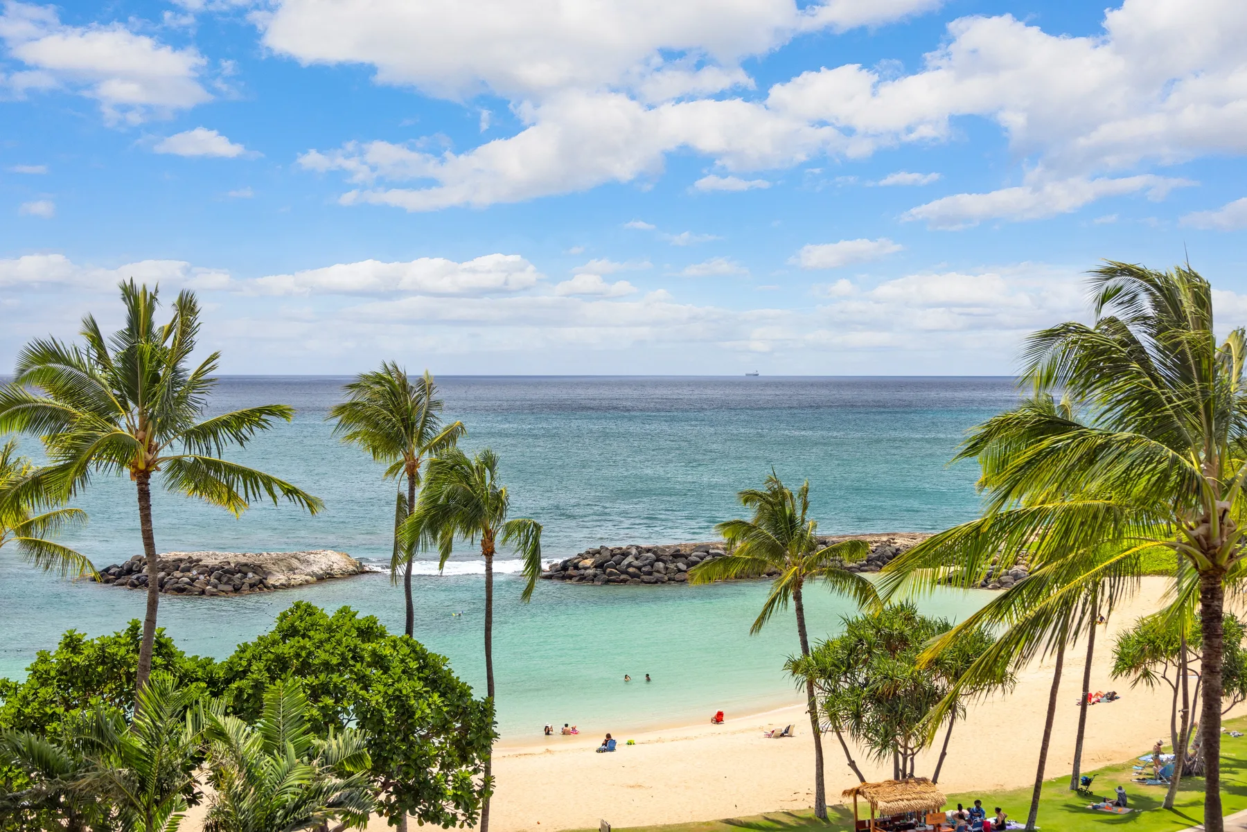 Una playa tropical con palmeras, agua turquesa y una orilla de arena.