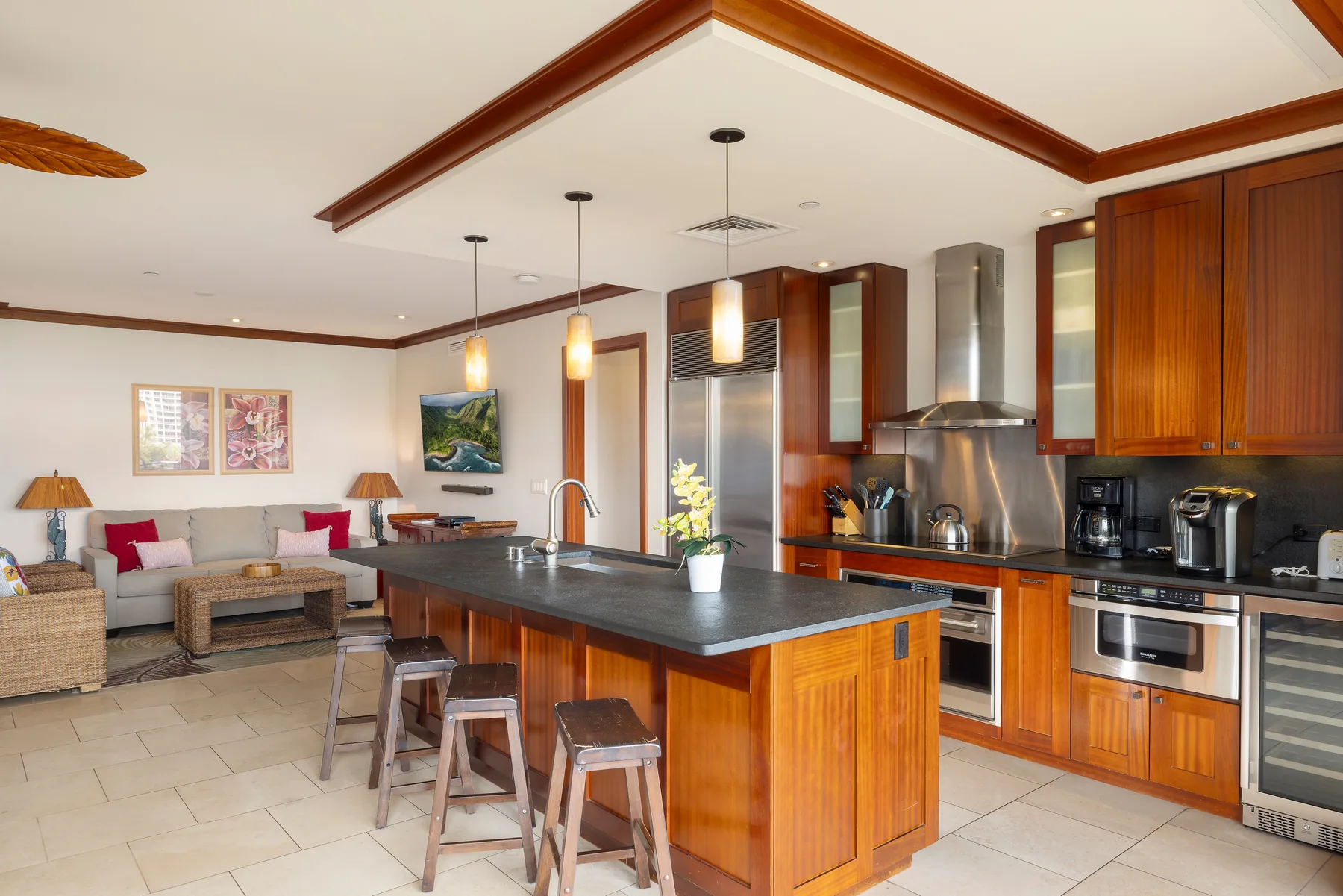 Una cocina abierta con comedor, una isla central y asientos de barra.
