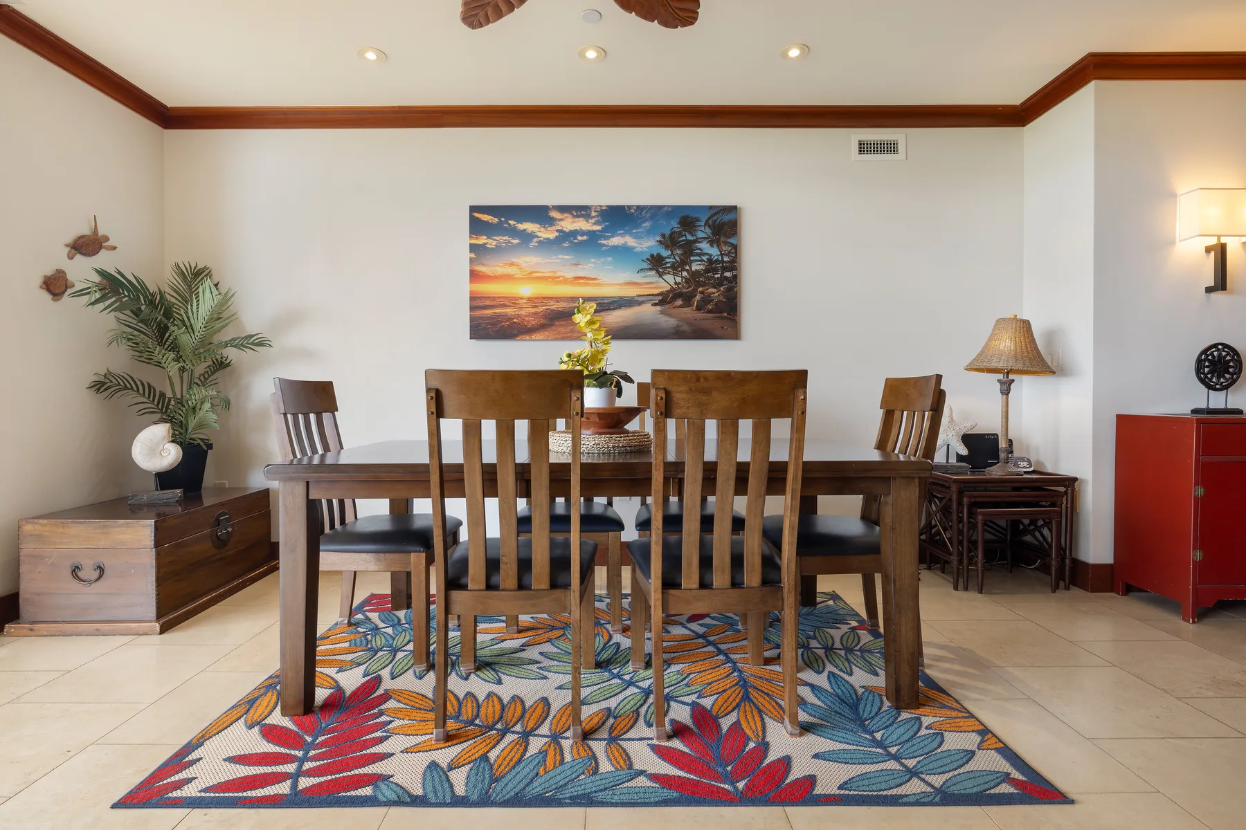 Comedor con una mesa de madera y sillas sobre una alfombra colorida.