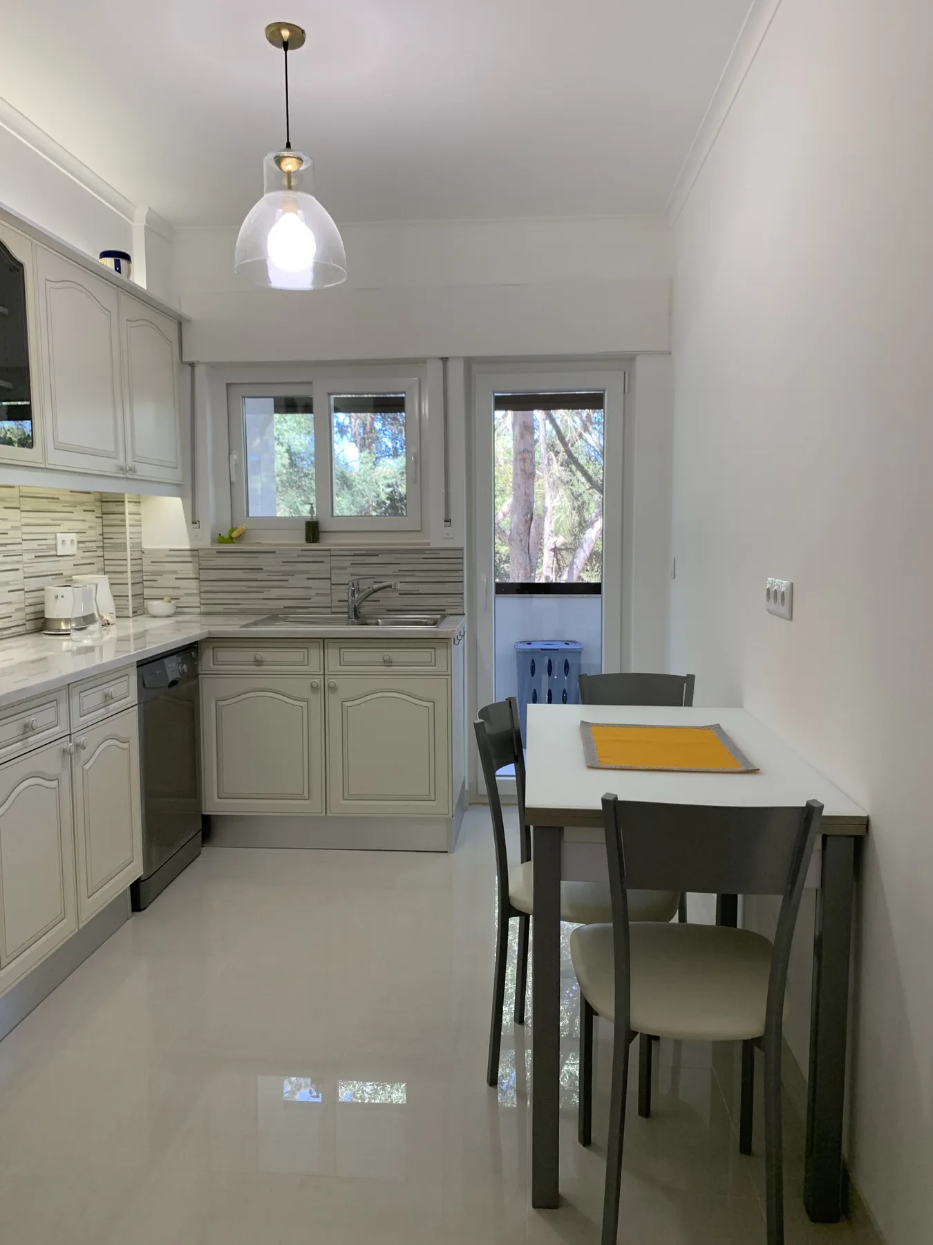 Una cocina luminosa con armarios, encimera y una mesa de comedor.
