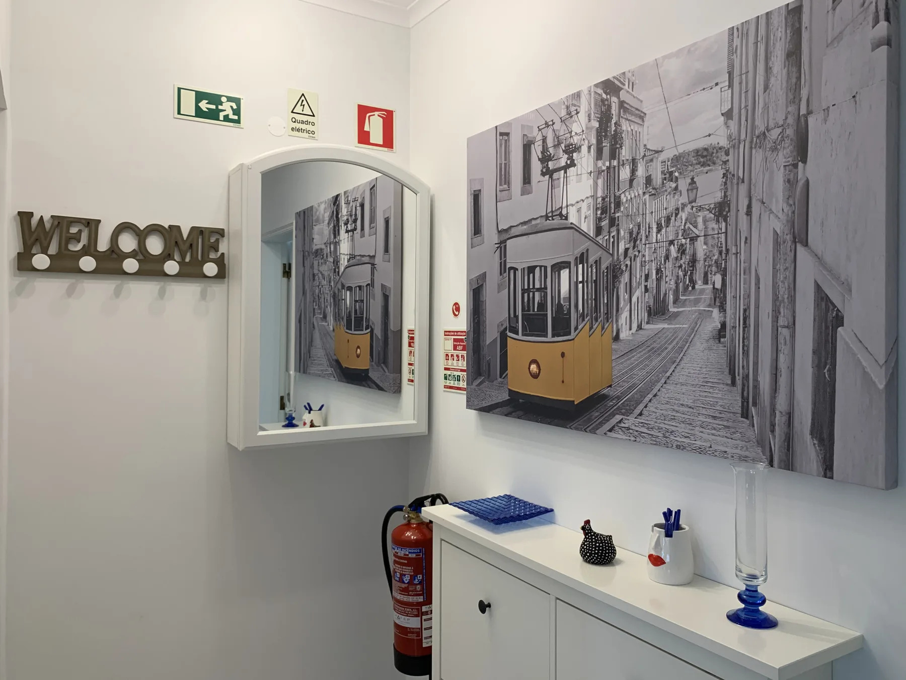 Una entrada luminosa tiene un gran mural de un tranvía sobre una consola blanca.