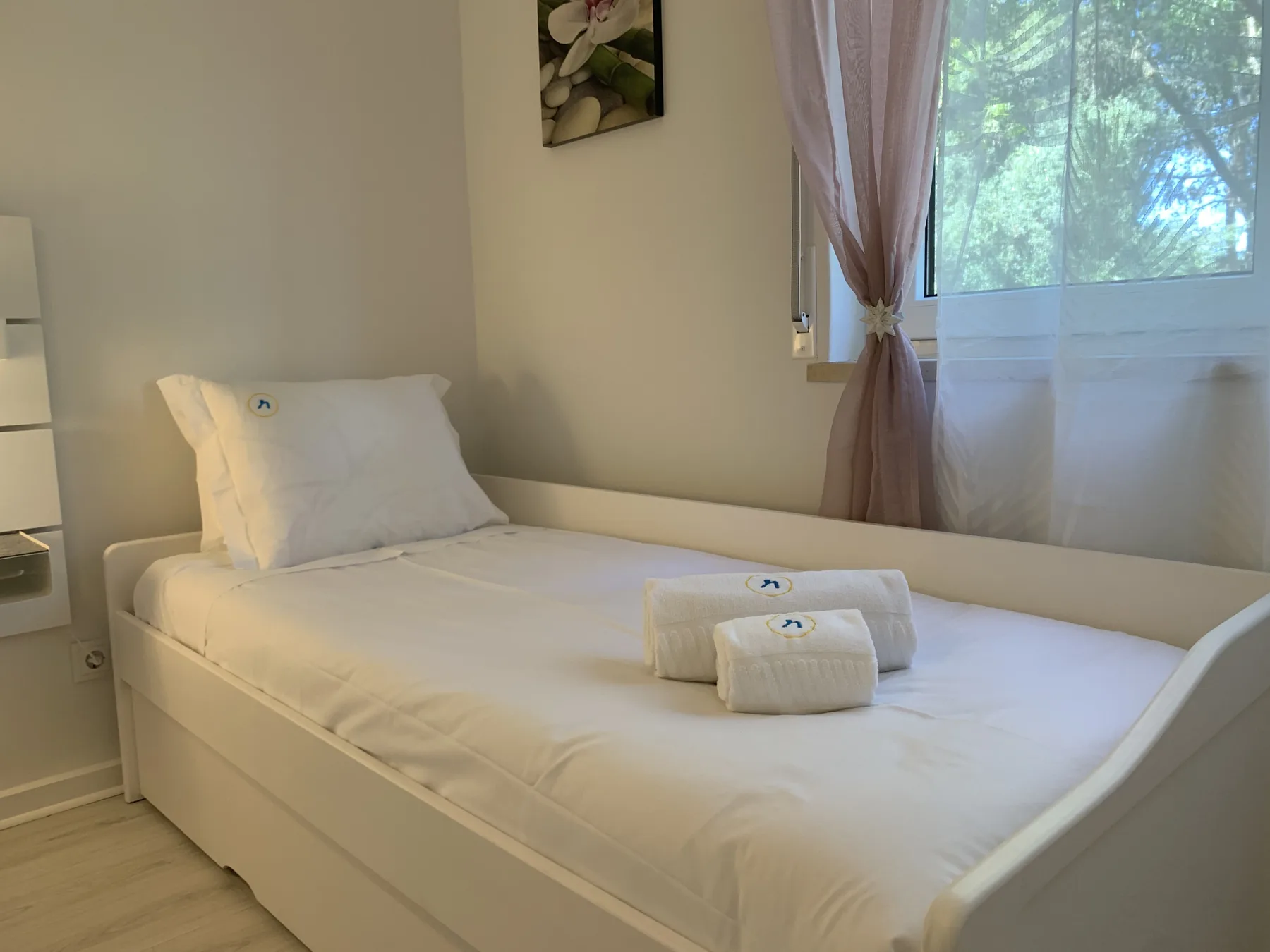 Un dormitorio con una cama bien hecha y toallas dobladas.