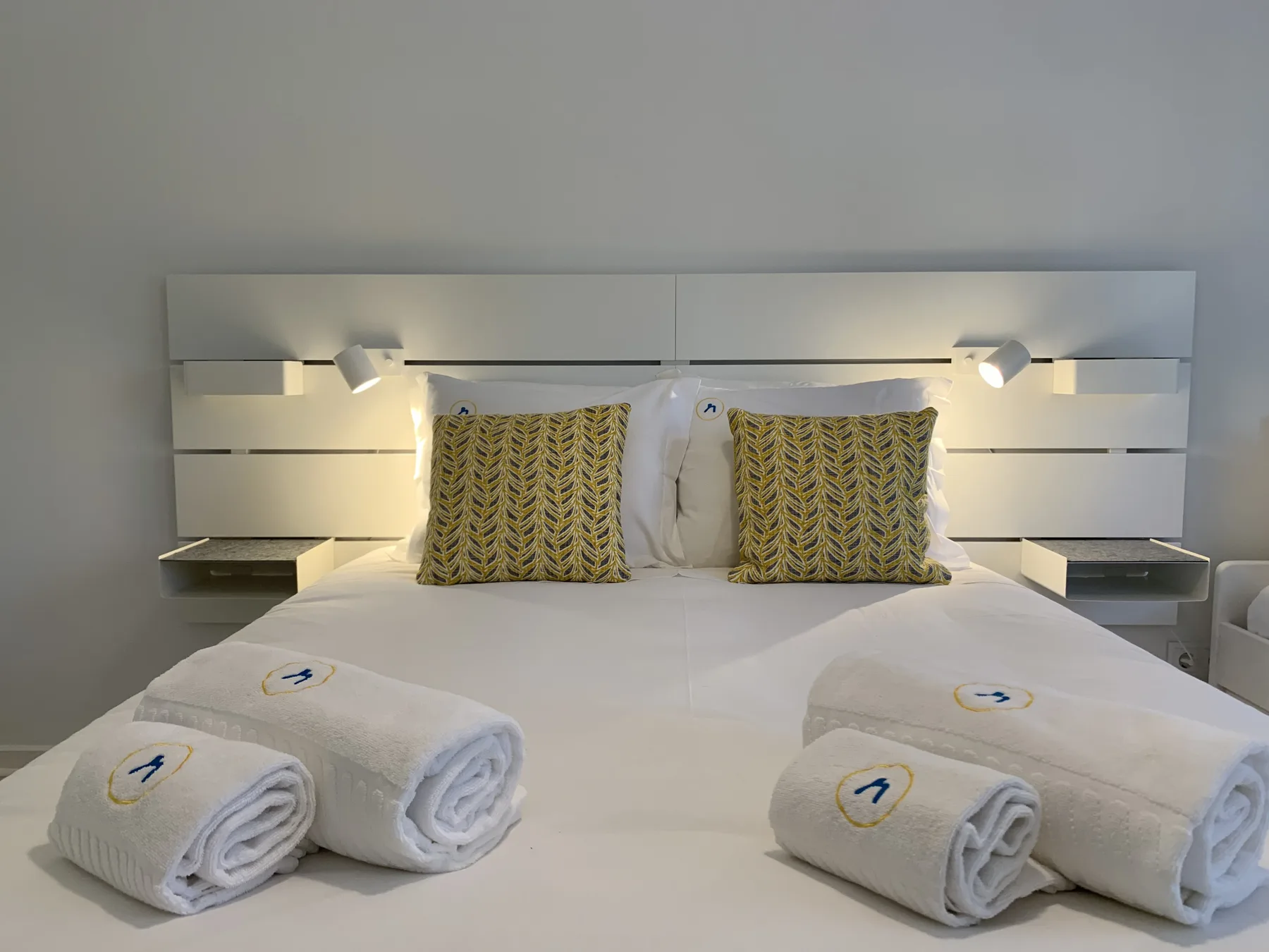 Un dormitorio con una cama bien tendida y toallas dobladas.