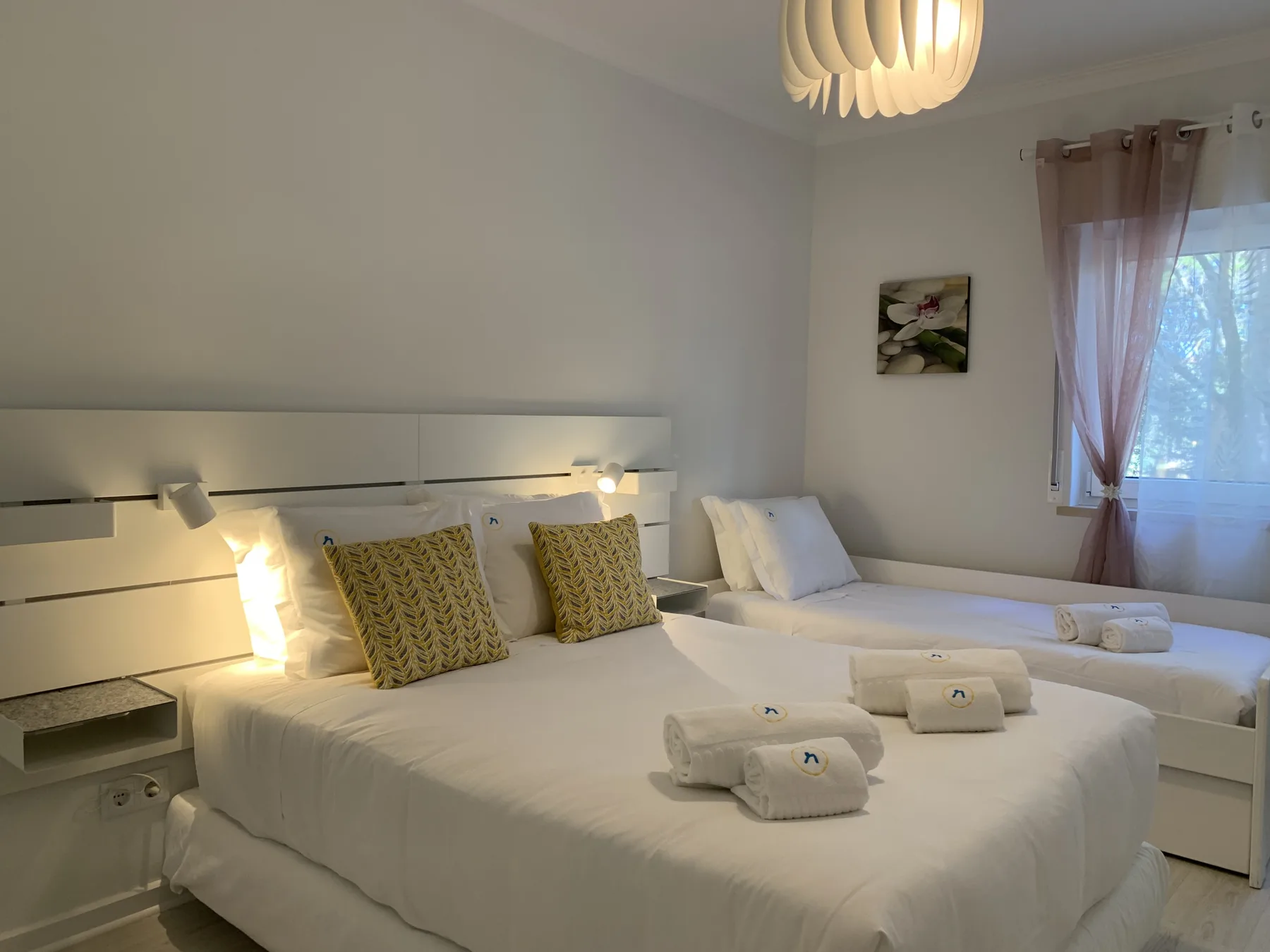Un dormitorio con una cama grande, luces junto a la cama y una ventana.