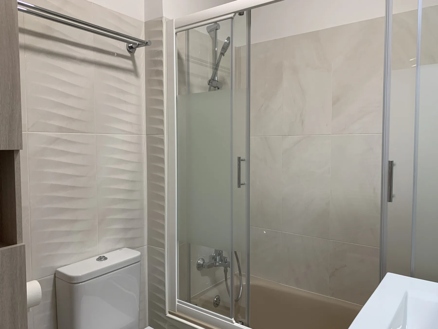 Baño con una ducha acristalada y un inodoro.