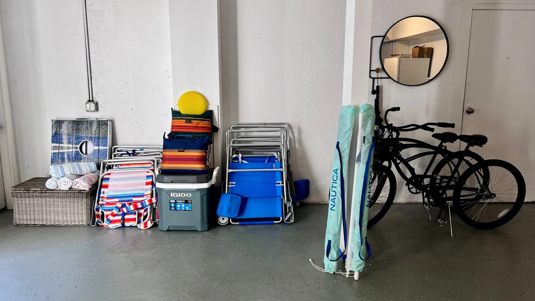A storage area with stacked beach gear and several bicycles.