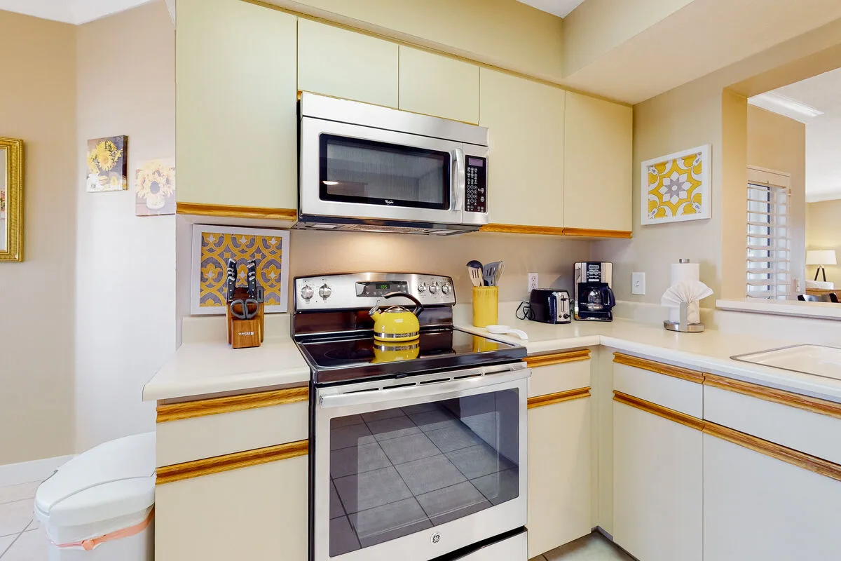 Una cocina luminosa con electrodomésticos empotrados y gabinetes de color claro.