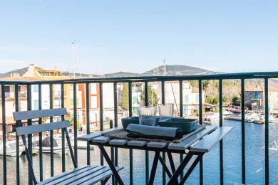 A balcony seating area overlooks a canal and nearby buildings.