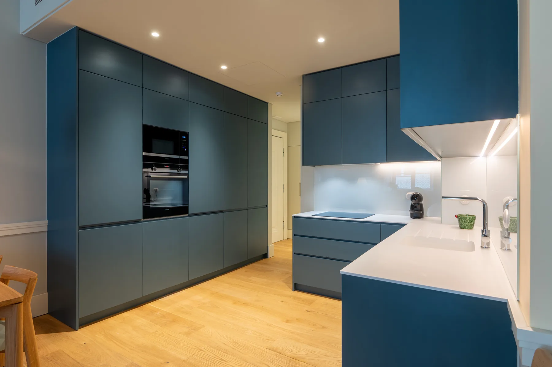 Una cocina moderna con armarios azules y una isla blanca.