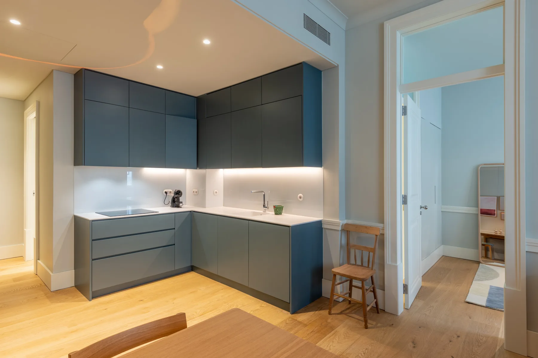 Una cocina moderna con gabinetes oscuros y suelo de madera clara.