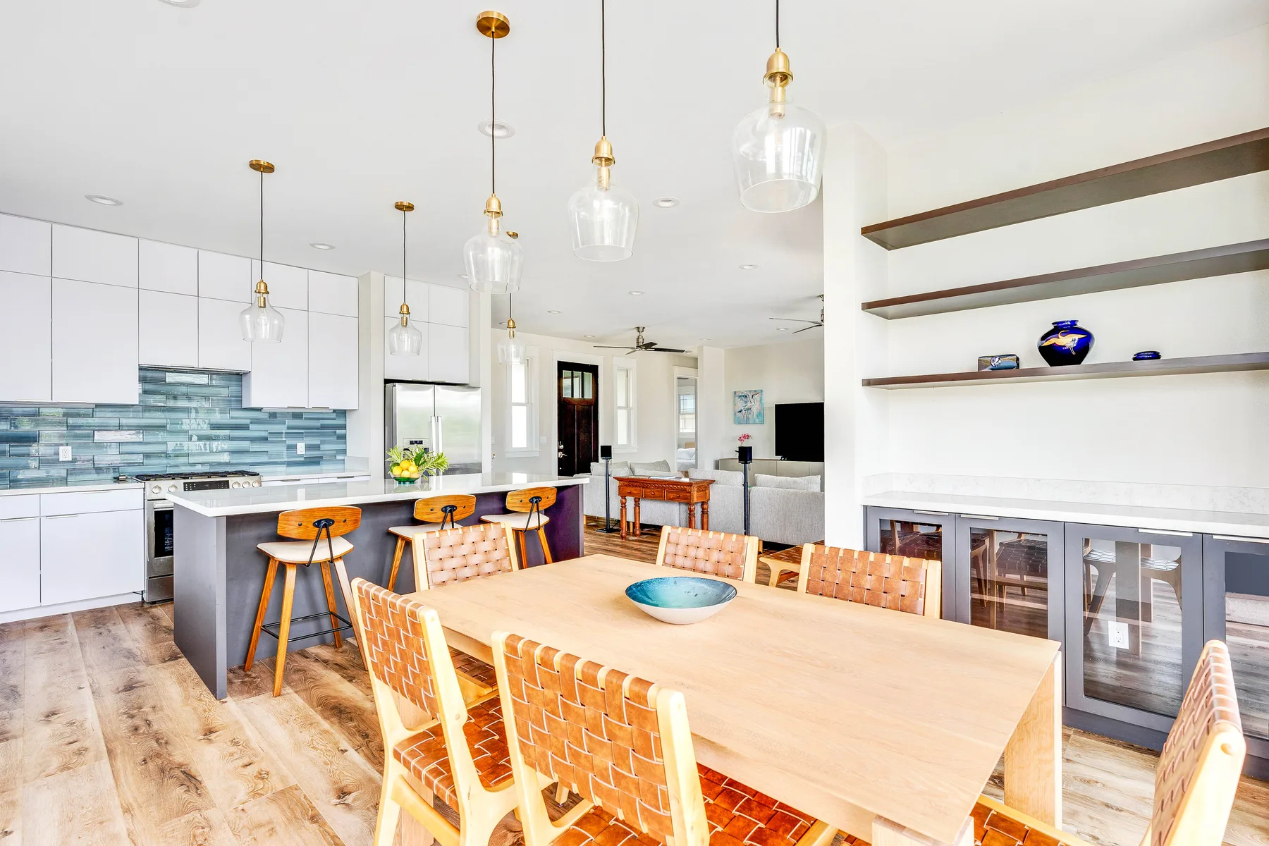 Una luminosa cocina abierta al comedor, con una larga mesa de madera.