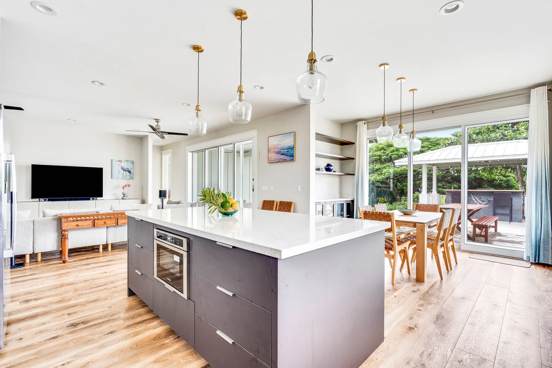 Una luminosa cocina-comedor de concepto abierto con una isla central y puertas de vidrio.