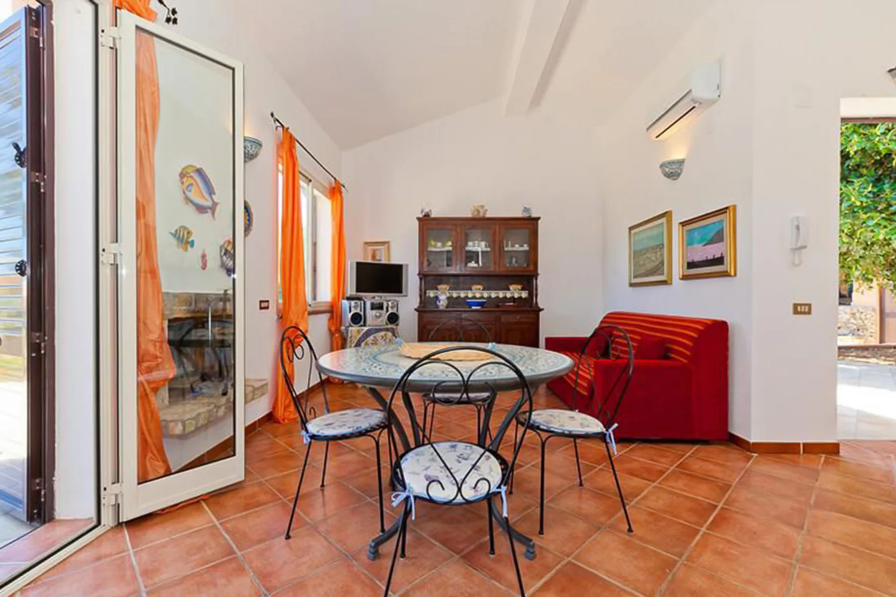 A dining area with a round table and red seating.