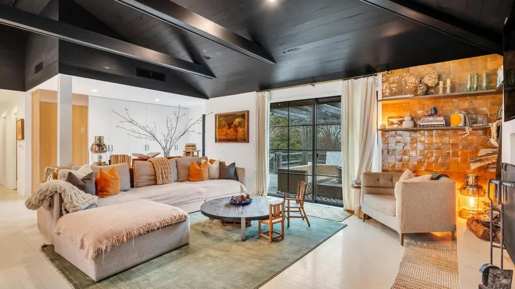 A living room with seating around a coffee table and sliding glass doors.