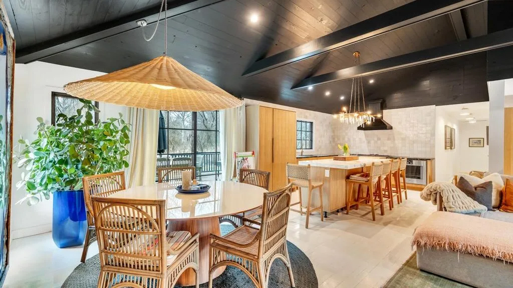 An open-plan dining and kitchen area with a round table and a long island.