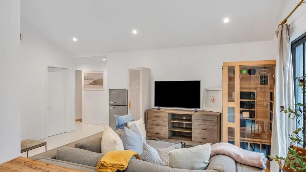 A bright living room with a television and seating area.