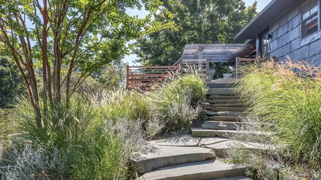 A landscaped garden path with stone steps leads toward a house.
