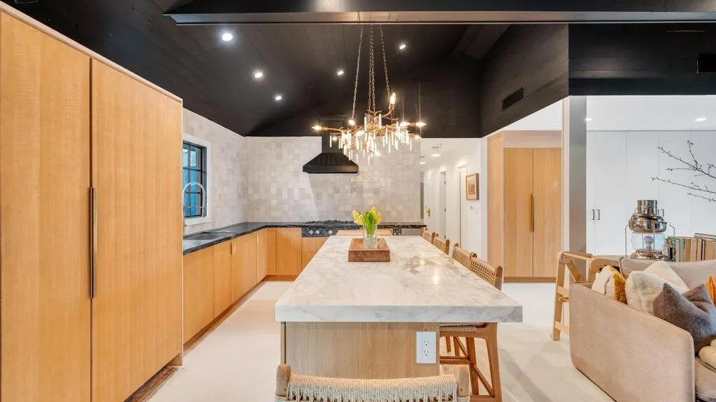An open-plan kitchen and dining area features wooden cabinetry and a large island.